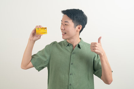portrait young Asian man holding credit card on white backgroundの写真素材