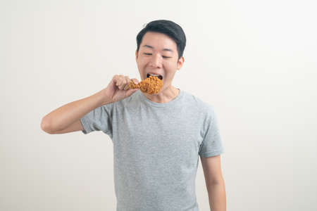 portrait young Asian man with fried chicken on handの写真素材