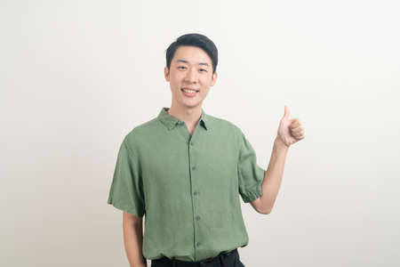 portrait young Asian man thumbs up or ok hand sign on white backgroundの写真素材