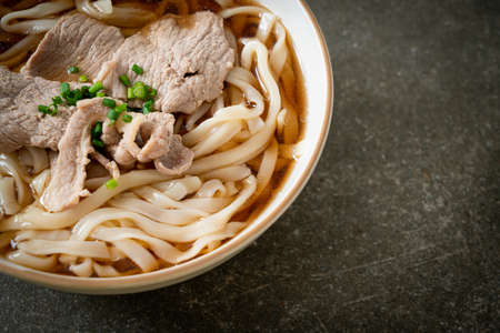 homemade udon ramen noodles with pork in soy or shoyu soupの写真素材