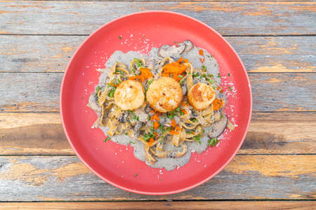 fettuccini spaghetti  with scallop truffle cream sauce on red plateの写真素材