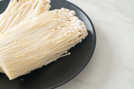 fresh enoki mushroom or golden needle mushrooms on plateの写真素材