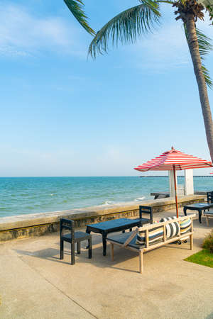empty bench sofa with umbrella and ocean sea background - holiday and vacation conceptの写真素材