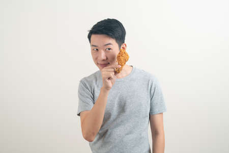 portrait young Asian man with fried chicken on handの写真素材