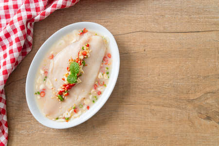Steamed Fish in Spicy Lemon Sauce on white plateの写真素材