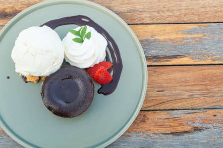 chocolate lava with vanilla ice-cream and whipping cream on plateの写真素材
