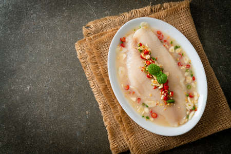 Steamed Fish in Spicy Lemon Sauce on white plateの写真素材