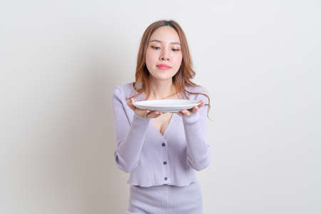 portrait beautiful Asian woman holding empty plate on white backgroundの写真素材
