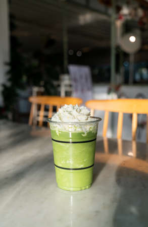 matcha green tea latte blend in glass with whipping cream
