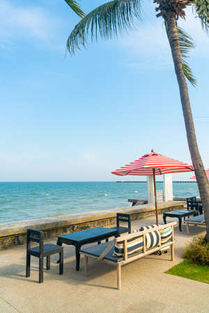 empty bench sofa with umbrella and ocean sea background - holiday and vacation conceptの写真素材