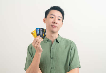 portrait young Asian man holding credit card on white backgroundの写真素材