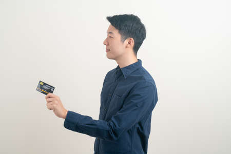 portrait young Asian man holding credit card on white backgroundの写真素材