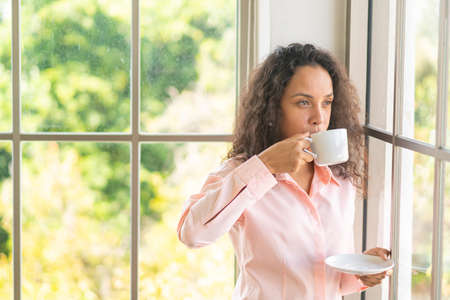 beautiful latin woman drinking coffee in the morning