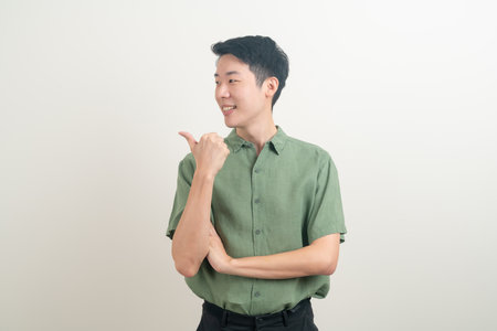 portrait young Asian man with hand pointing or presenting on white backgroundの写真素材