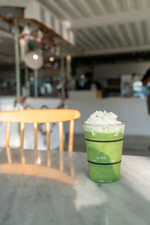 matcha green tea latte blend in glass with whipping creamの写真素材
