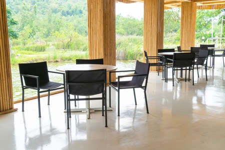 empty table and chair in restaurant with nature viewの写真素材