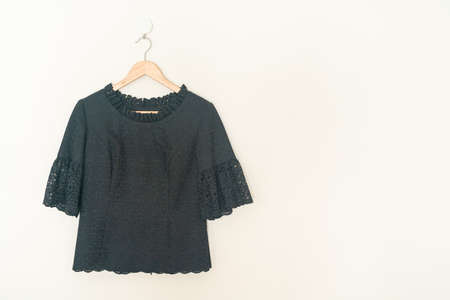beautiful woman shirt hanging with wood hanger on wall