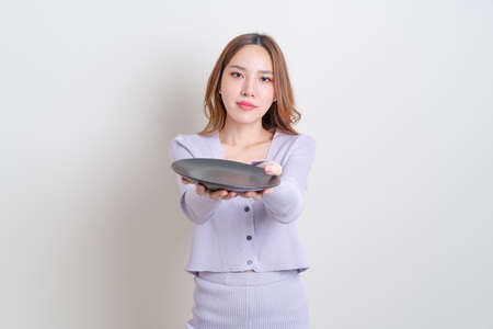 portrait beautiful Asian woman holding empty plate on white background