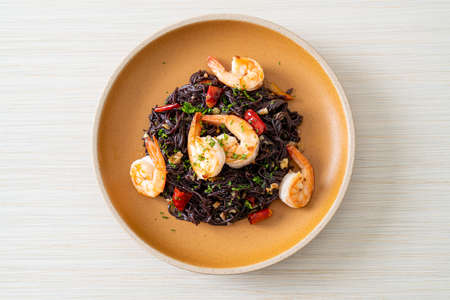 stir-fried black spaghetti with garlic and shrimps on plateの写真素材