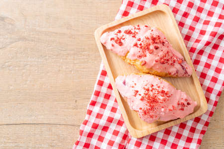 croissant with strawberry chocolate sauce on wood plate