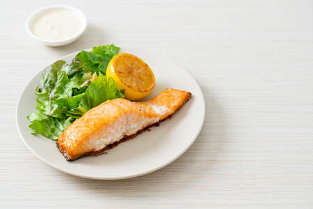 homemade fried salmon steak with lemon and vegetable - healthy food style