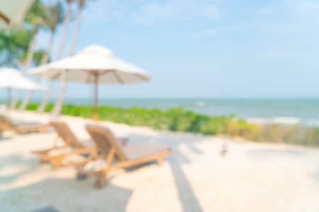 abstract blur umbrella with beach chair and ocean sea for backgroundの写真素材