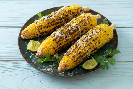 barbecue and grilled corn with cheese and lime on plate