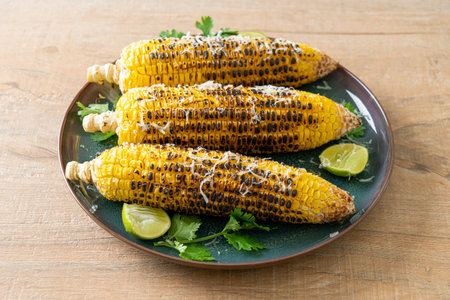 barbecue and grilled corn with cheese and lime on plate
