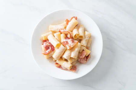 homemade spaghetti rigatoni pasta with white sauce and bacon - Italian food styleの写真素材