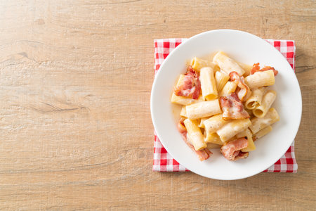 homemade spaghetti rigatoni pasta with white sauce and bacon - Italian food styleの写真素材