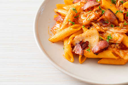 stir-fried penne pasta with kimchi and bacon - fusion foodの写真素材