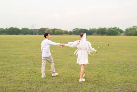 Happy young Asian couple in bride and groom clothing ready for marry and wedding celebrateの写真素材