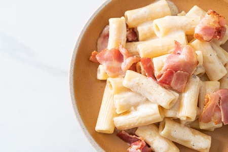 homemade spaghetti rigatoni pasta with white sauce and bacon - Italian food style