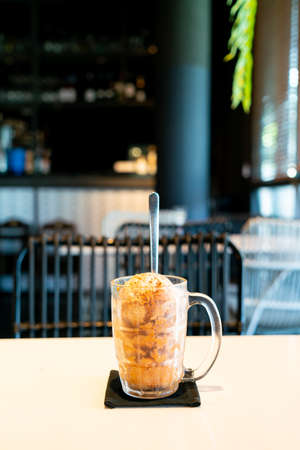 Thai tea ice scoop in glass on table in coffee shop cafe and restaurant