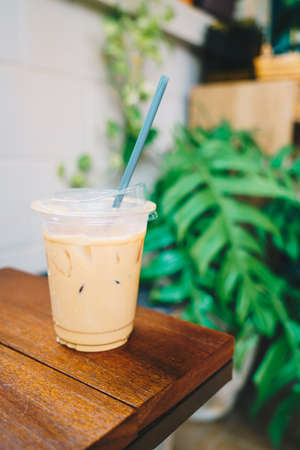 latte coffee in take away glass wood on tableの写真素材