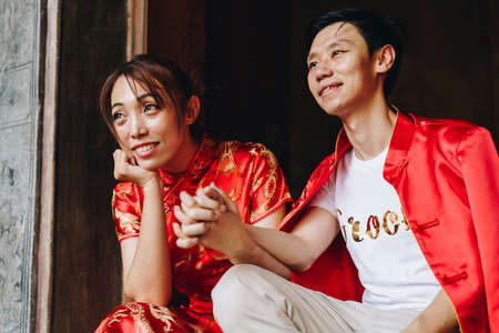 Happy young Asian couple love in Chinese traditional dresses - Red is the main color of the...