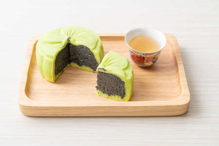 Chinese moon cake green tea flavour with tea on wood plate