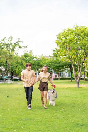 Asian couple love with cute dog in gardenの写真素材