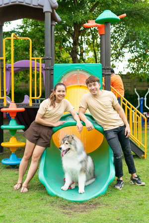 Asian couple love with cute dog in gardenの写真素材