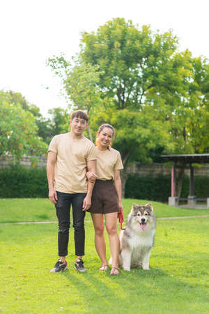 Asian couple love with cute dog in gardenの写真素材