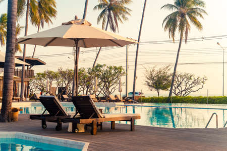 umbrella with bed pool around swimming pool with ocean sea background - holiday and vacation conceptの写真素材