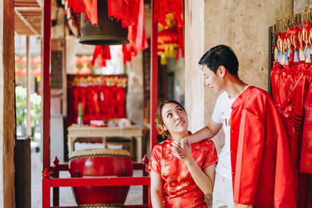 Happy young Asian couple love in Chinese traditional dresses - Red is the main color of the traditional festive that including wedding in China.の写真素材