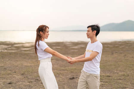 Happy young Asian couple in bride and groom t-shirt ready for marry and wedding celebrateの写真素材