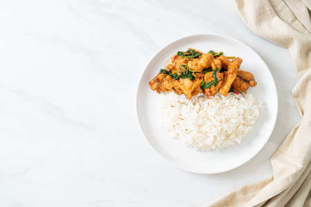 stir-fried fried fish with basil and chili in thai style topped on rice - Asian food styleの写真素材