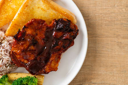 barbecue pork steak with rice berry on white plateの写真素材