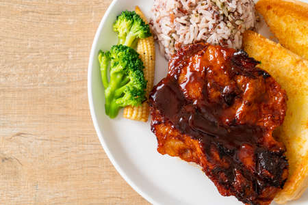 barbecue pork steak with rice berry on white plateの写真素材