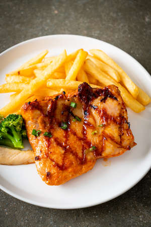 grilled chicken steak with potato chips or french fries on white plate