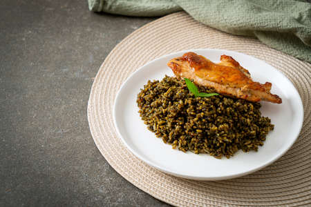 pesto fried rice with grilled chicken on white plateの写真素材
