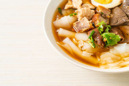 paste of rice flour or boiled Chinese pasta square with pork in brown soup - Asian food styleの写真素材