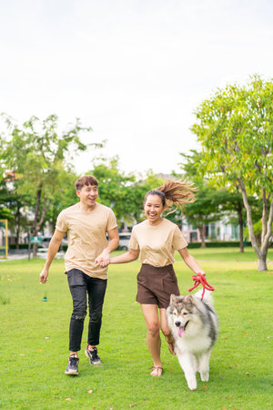 Asian couple love with cute dog in gardenの写真素材